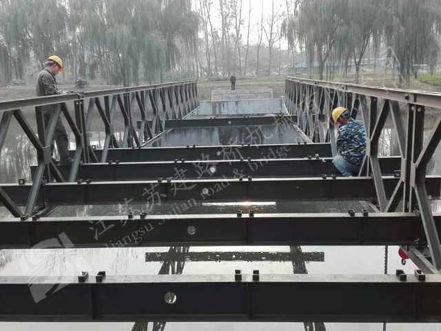 Steel bridge workers installing modular panels for temporary and landscape bridge projects