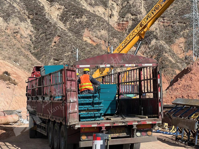 Truck unloading prefabricated steel bridge panels for Yellow River construction access
