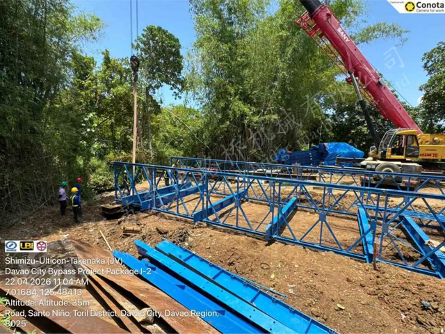 Workers installing a prefabricated steel bridge with a crane in Davao City