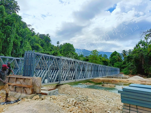 Prefabricated Bailey truss bridge spanning a rocky river crossing